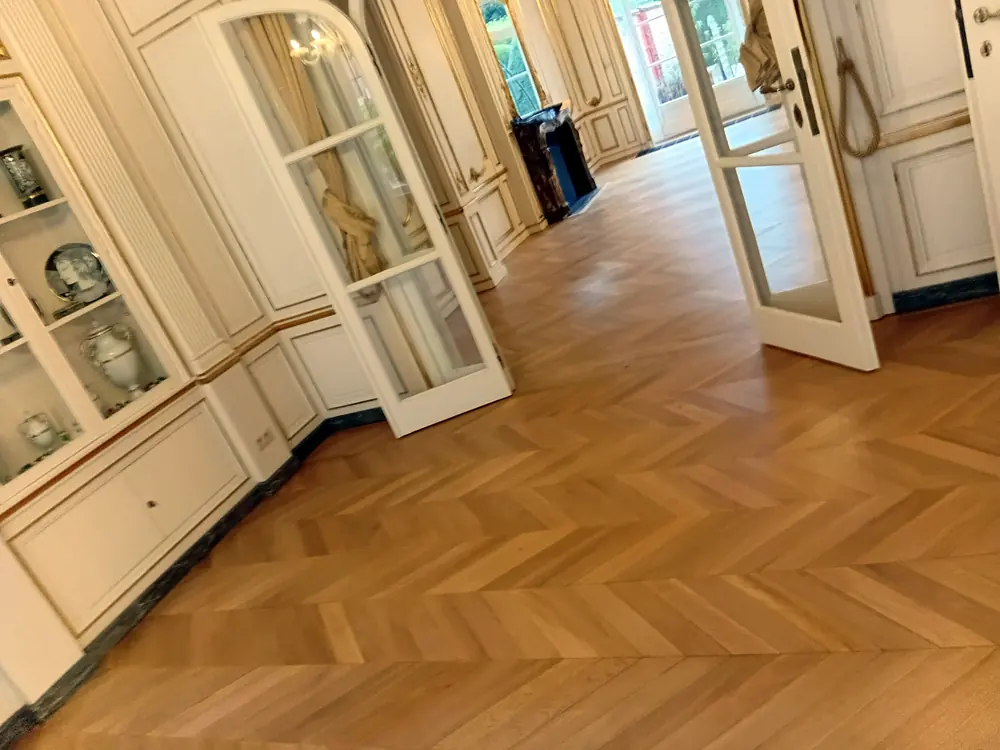 Enfilade de salons avec un parquet à chevrons rénové