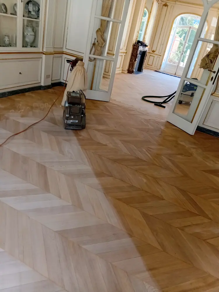 Ponçage d’un parquet à chevrons avec une ponceuse à bande